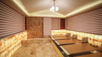 Relax in a serene space with massage tables, cushioned comfort, and ample lighting.