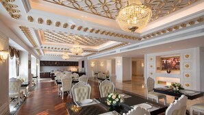 A spacious dining area with a long table, elegant chairs, and chandeliers. - Wyndham Grand Kunming East (Kunming)