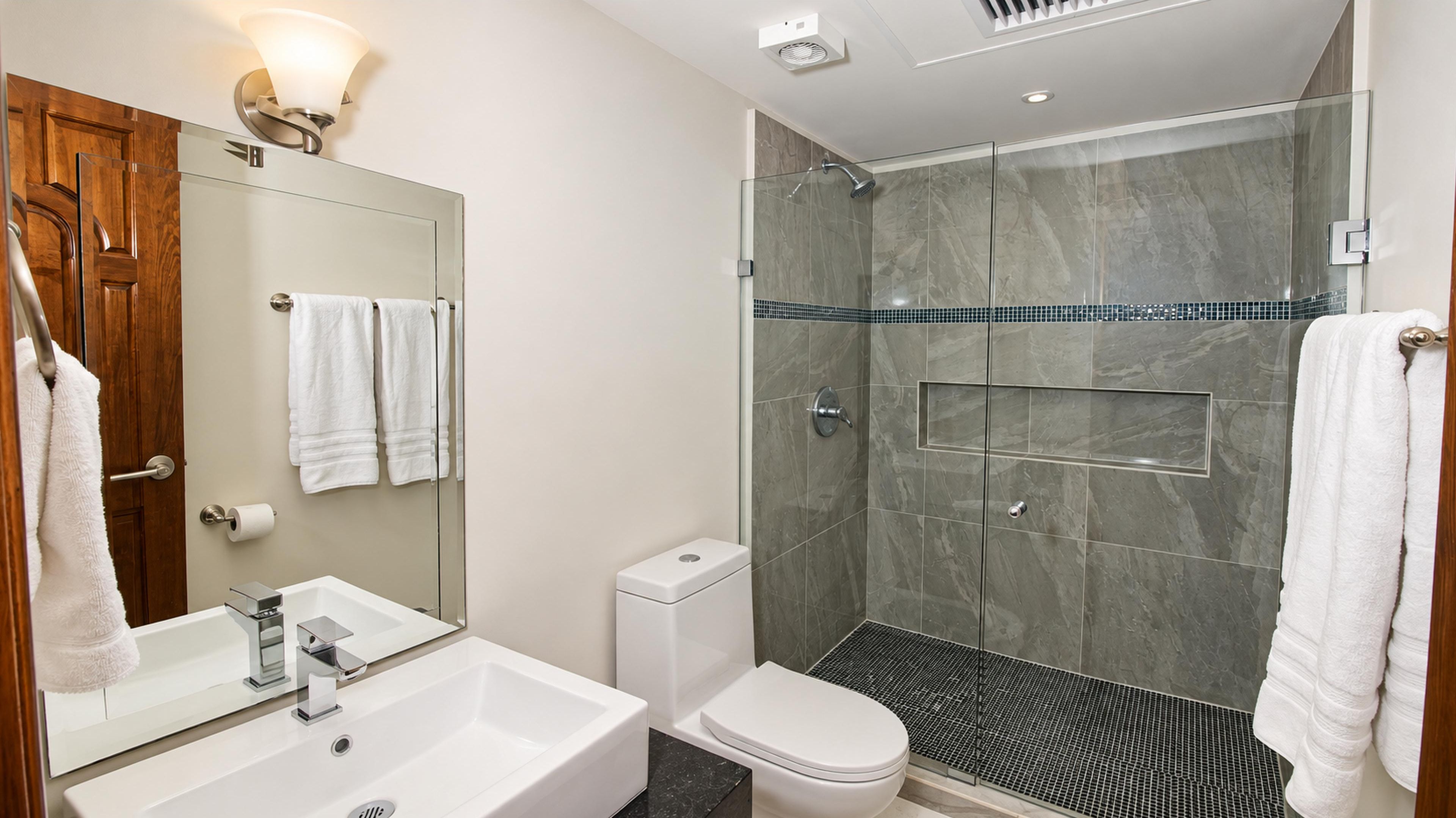 Bedroom 4’s private bathroom with a vessel sink and glass-enclosed shower with a recessed shelf.