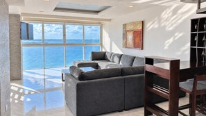 Sunlit living room with sectional seating and an adjoining indoor bar/desk at Penthouse 3704.