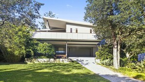 A modern two-story house with a flat roof, a covered driveway, and a well-maintained lawn. - At The Beach - Great Family House (North Avoca)