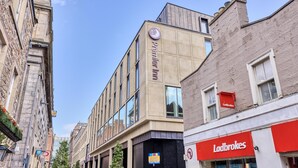 A modern building with a prominent 'Premier Inn' sign, a 'Ladbrokes' sign, and a 'No Entry' sign. - Premier Inn Edinburgh Cc Waverley (Edinburgh)
