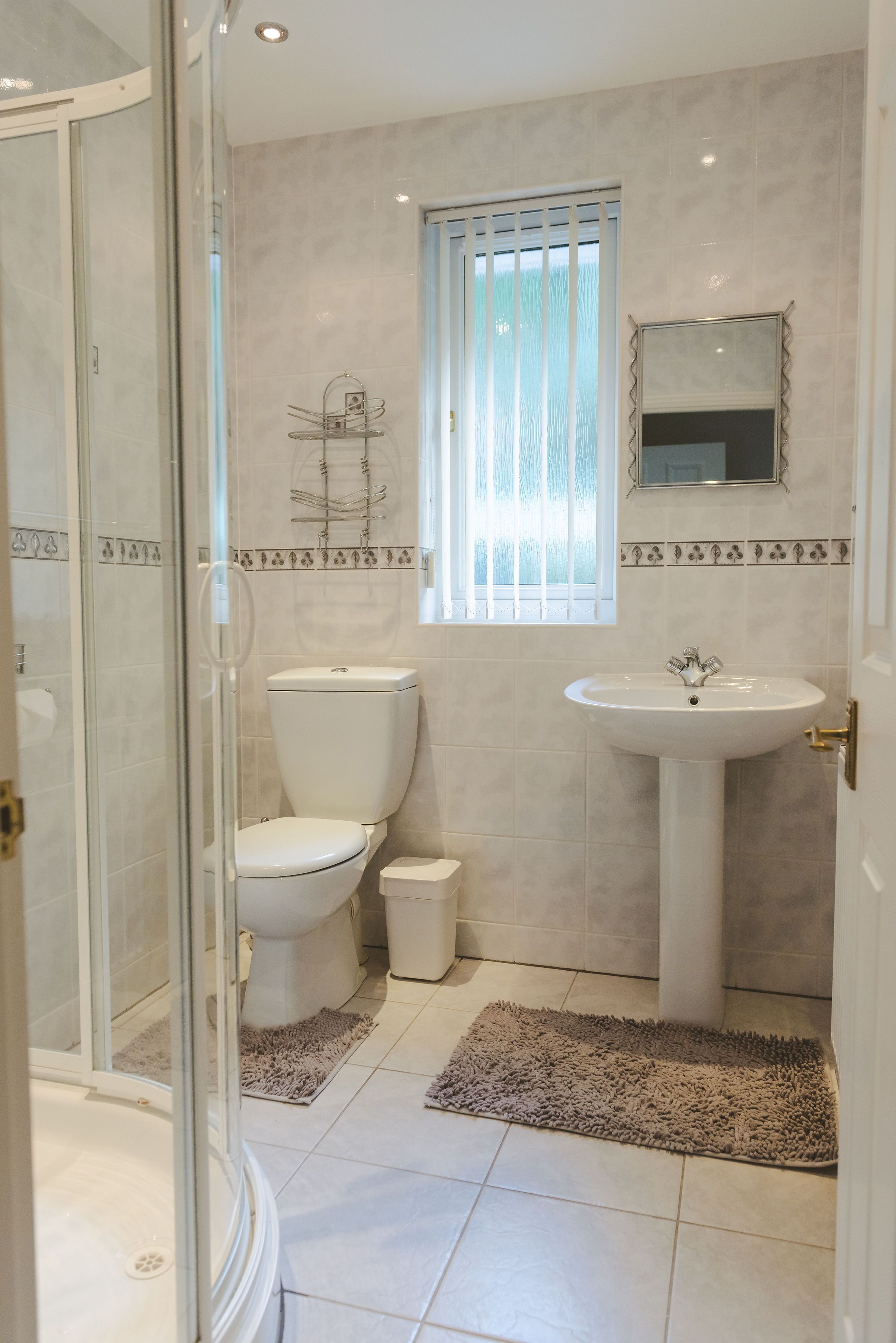 A bathroom with a toilet, sink, and shower area.