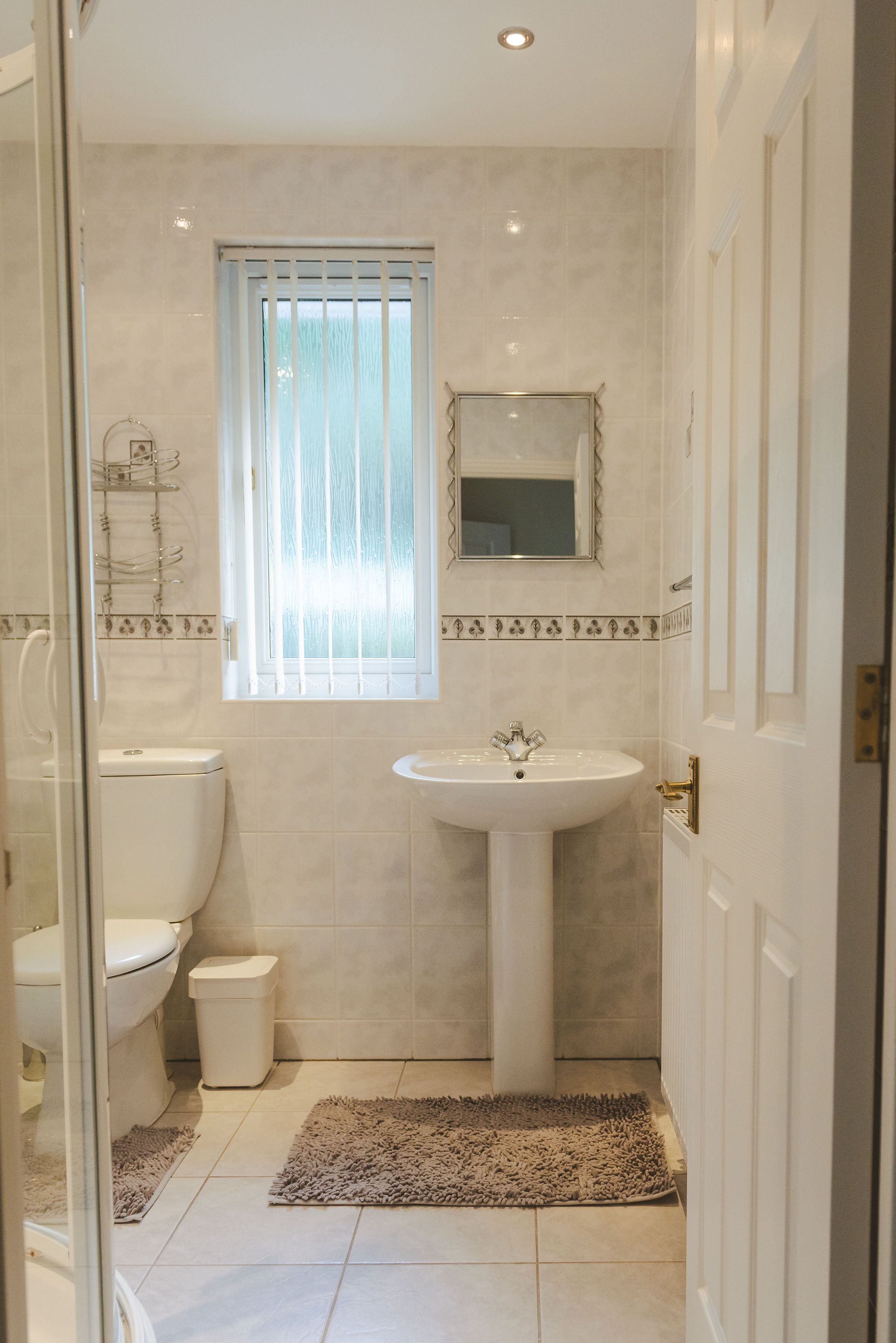 Un baño pequeño con inodoro, lavamanos y ducha.