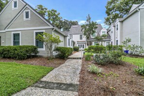 A residential area with houses, a gravel pathway, and well-maintained lawns.
