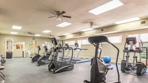 Ein Fitnessstudio mit Laufbändern, Crosstrainern und Gewichten.
