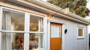 Un petit bâtiment d’un seul étage, doté d’une porte en bois et de deux fenêtres.