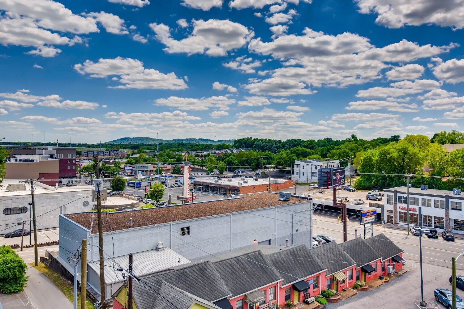 A commercial area with various buildings, including a large industrial structure and smaller shops.
