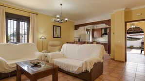 Una sala de estar con sofá, una mesa de centro y un comedor con mesa y sillas.