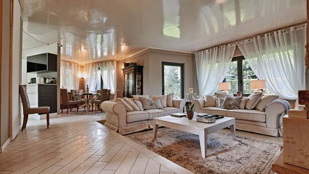 Un espacio habitable amplio con un conjunto de sofás, una mesa de centro y una mesa de comedor con sillas.