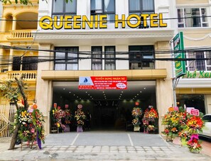 The Queenie Hotel entrance with a signboard and floral decorations. - Queenie Hotel (Hai Phong)
