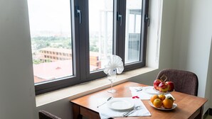 A dining table with a white plate, a wine glass, and a fruit arrangement. - Queenie Hotel (Hai Phong)