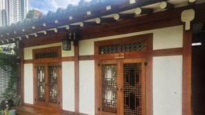Il s’agit d’un bâtiment traditionnel en bois, doté d’un toit en tuiles, de portes en bois ornées de motifs en treillis et d’un petit porche.