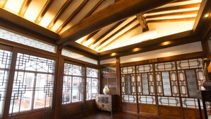 Une pièce de style traditionnel avec des poutres en bois, un sol recouvert de tatamis et des paravents shoji.