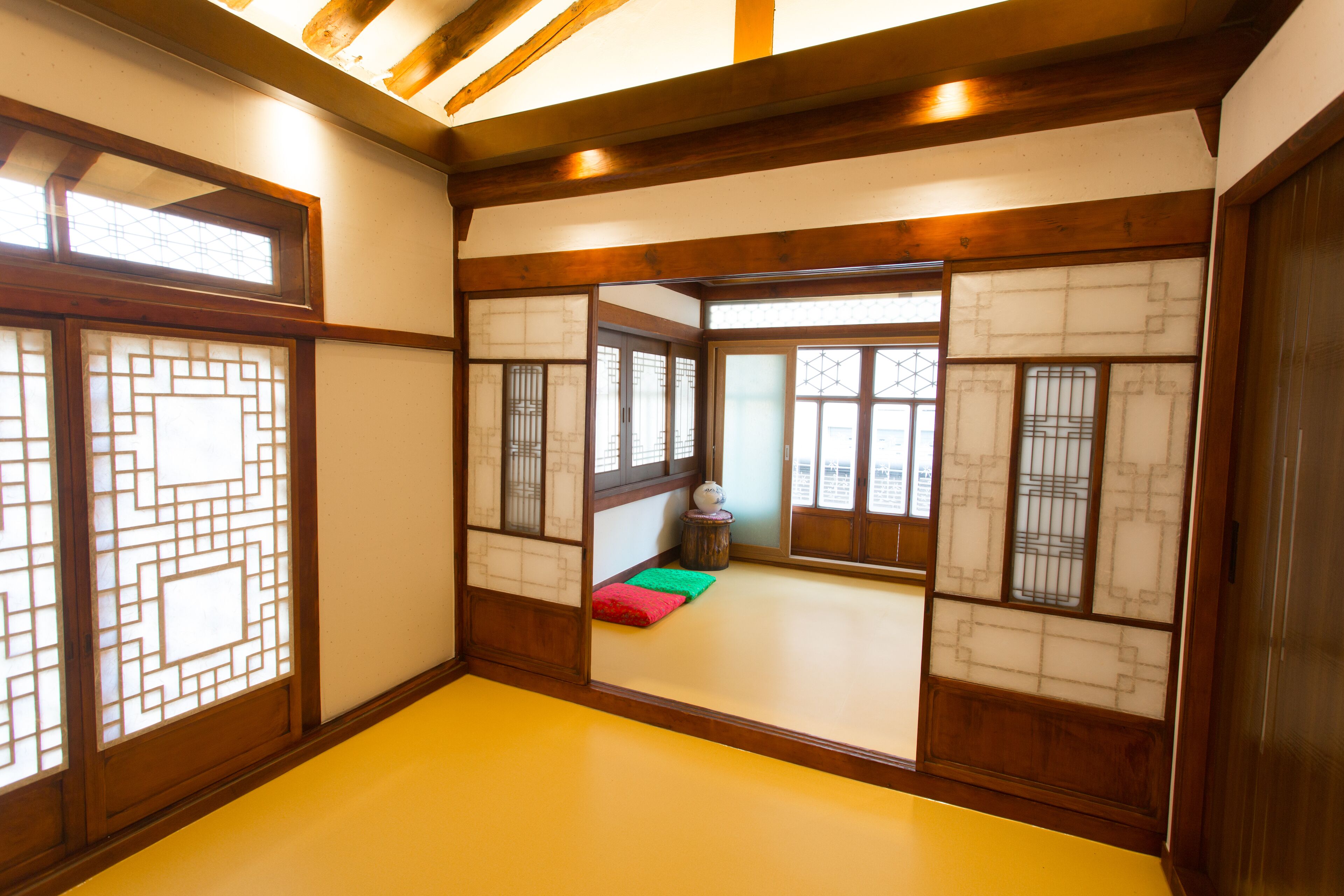 Une pièce de style japonais traditionnel, avec un sol recouvert de tatamis, des paravents en papier de riz (shoji) et un plafond bas en bois.