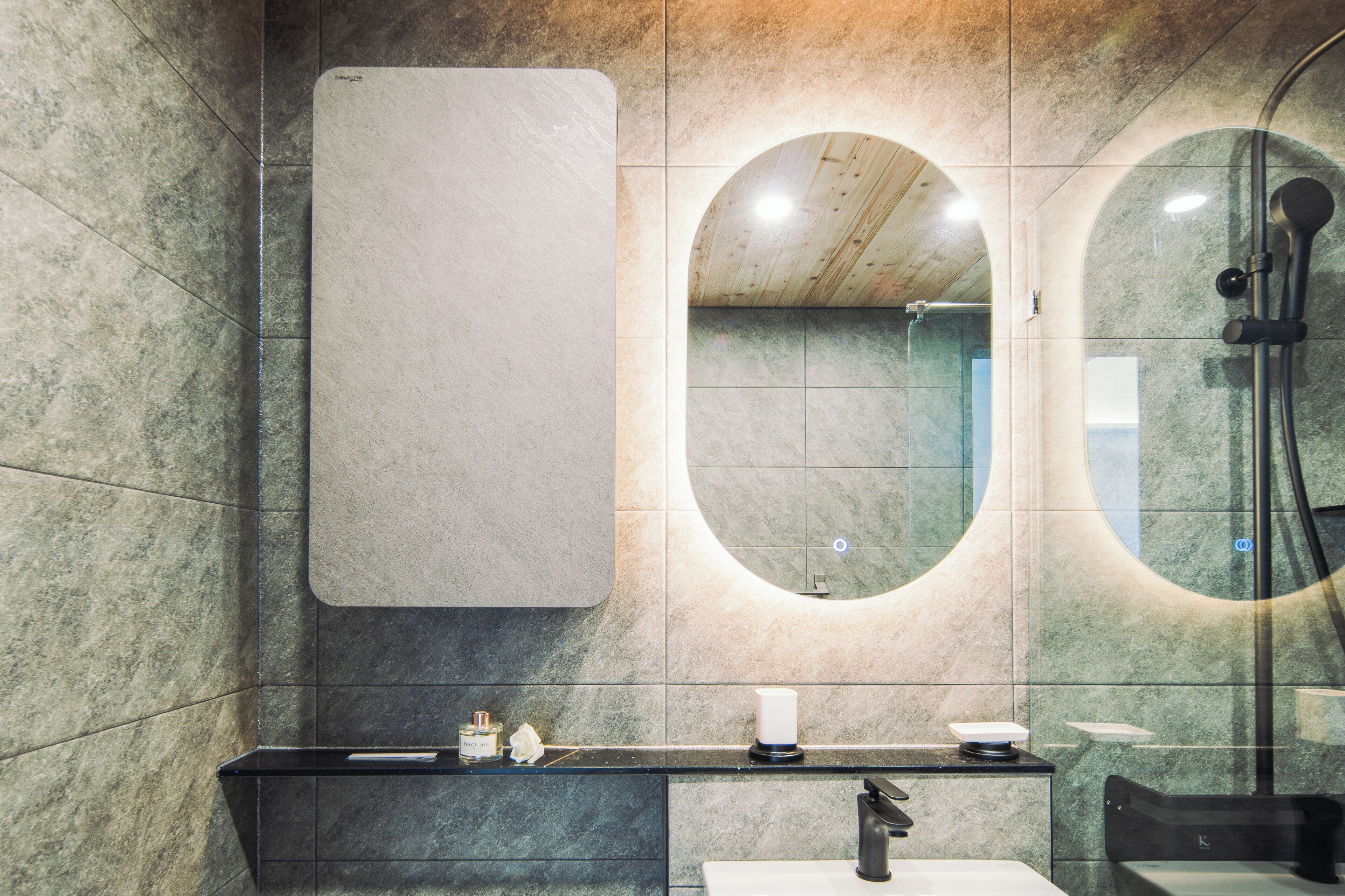 Een moderne badkamer met een grote spiegel, een douche en een wastafelmeubel met een wastafel.