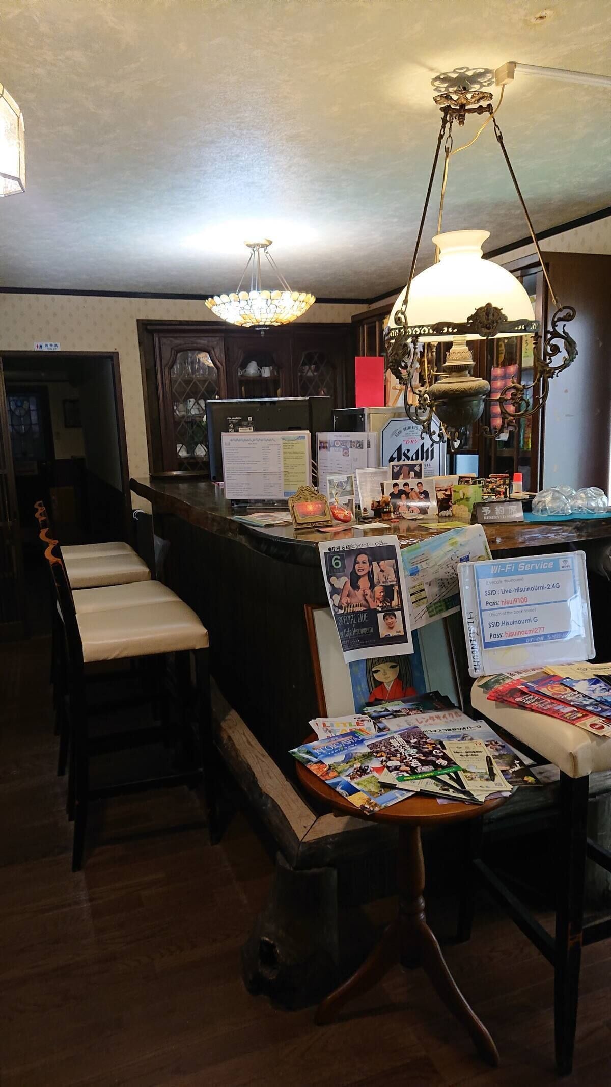 A reception area with a counter, chairs, a chandelier, and various informational posters.