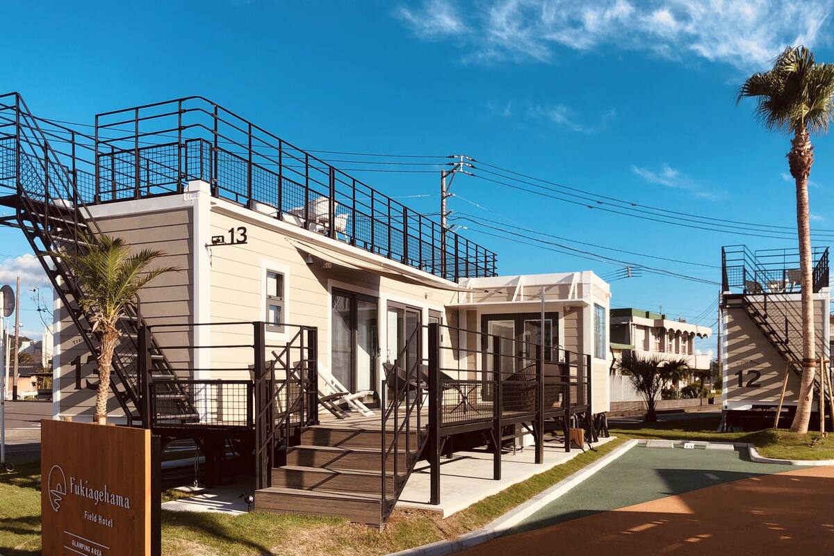 Un hôtel doté d’une terrasse, d’un escalier et d’une enseigne indiquant le « Fukiagehama Field Hotel ».