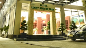 L’entrée d’un hôtel, avec une enseigne indiquant : « Hôtel Lucky Star ».