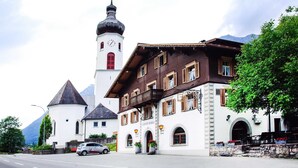 A traditional building with a clock tower, a balcony, and a sign that reads "Gisthof Russel." - Single room - Gasthof Rössle (Innerbraz)