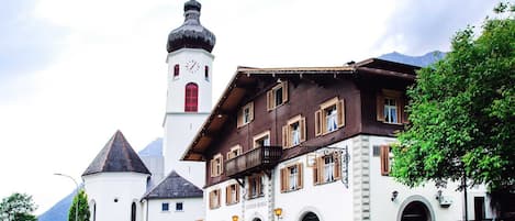 A traditional building with a clock tower, a balcony, and a sign that reads "Gisthof Russel."