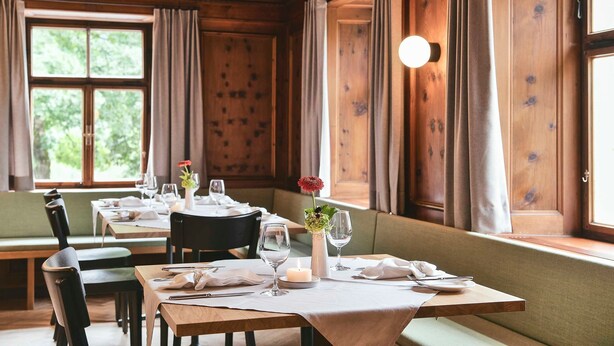 A dining area with wooden paneling, large windows, and a cozy ambiance. - Single room - Gasthof Rössle (Innerbraz)
