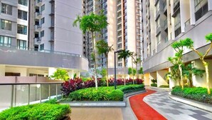 A modern residential building with multiple floors, landscaped courtyards, and a red pathway. - R&F PRINCESS COVE BY HOMEFORT SUITES (Johor Bahru)