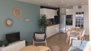 Ein modernes Wohnzimmer mit Fernseher, Sofa und Couchtisch.
