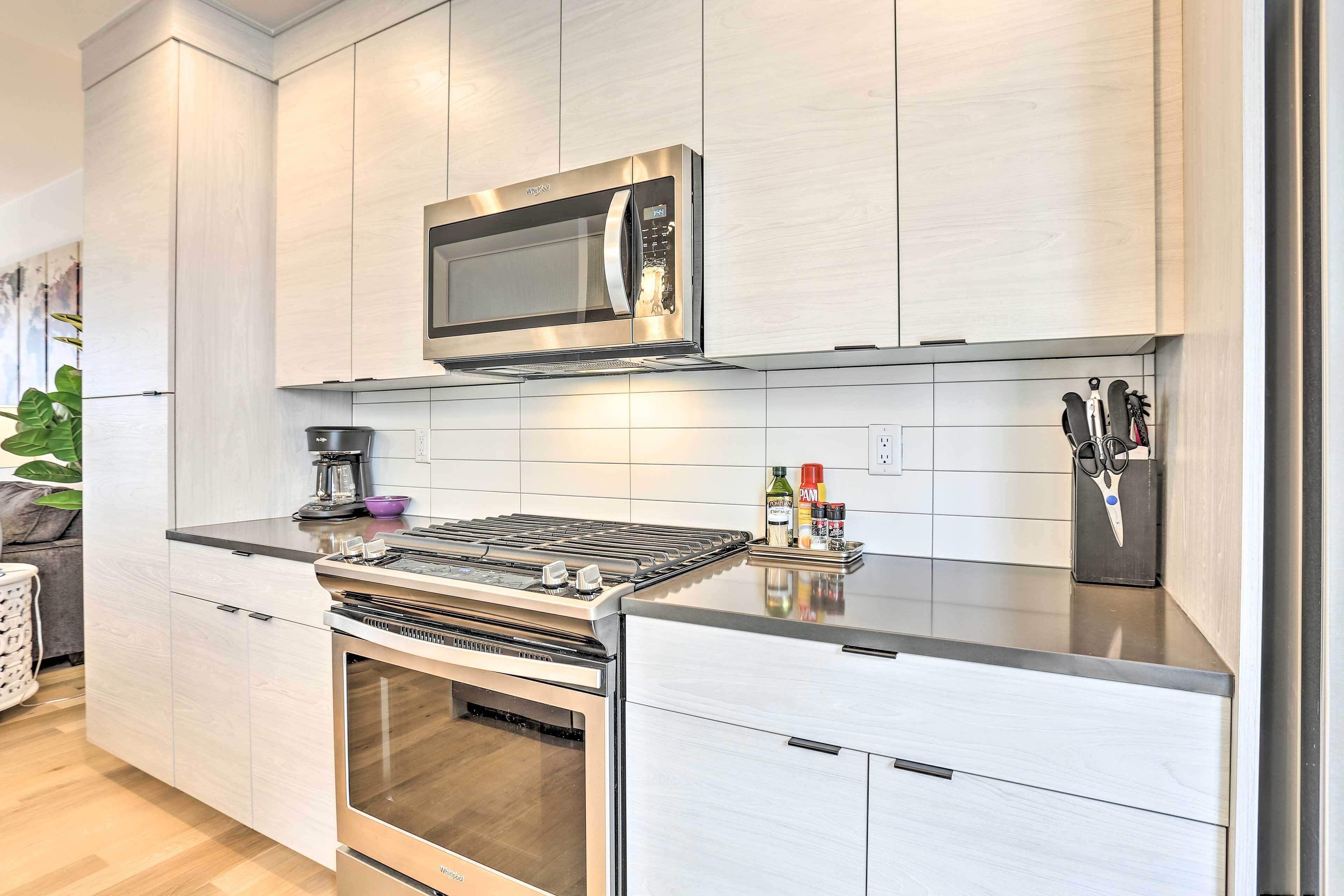 A modern kitchen with stainless steel appliances, including a microwave, oven, and gas stove.