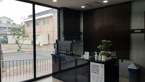 A reception desk with a computer, a trash bin, and a potted plant. - Daecheon 323 Condo (Boryeong)