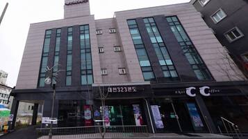 A modern building with a large entrance, signage for 'Choi Coffee', and a visible address 'No. 323'.