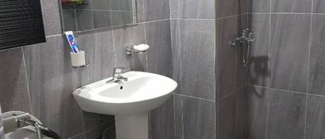 A bathroom with a toilet, sink, and shower.