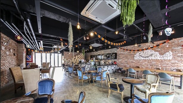 A cafe with brick walls, hanging plants, and a bar area. - Daecheon 323 Condo (Boryeong)