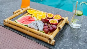 A poolside setting with a tray of fruits and a drink. - Memorina Ninh Binh Resort (Tay Hoa Lu)