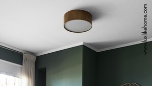 Uma sala de estar moderna com lareira, um espelho grande e um sofá verde.