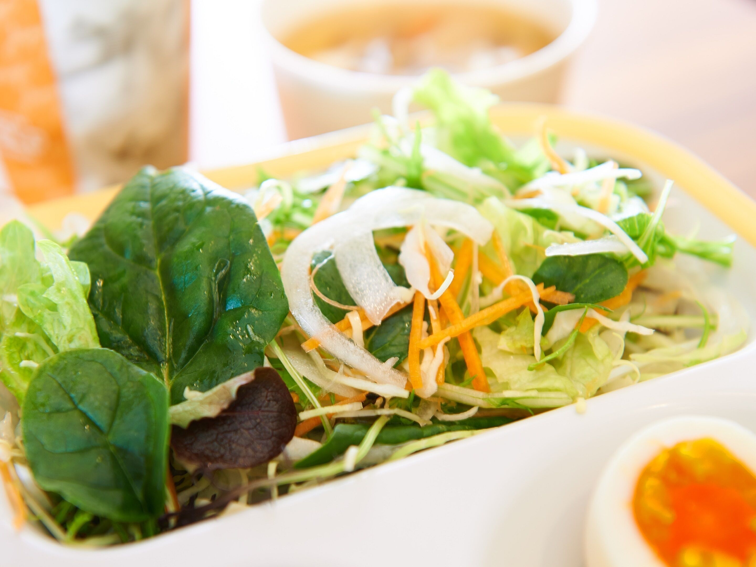 A close-up of a fresh salad with various greens and shredded vegetables.