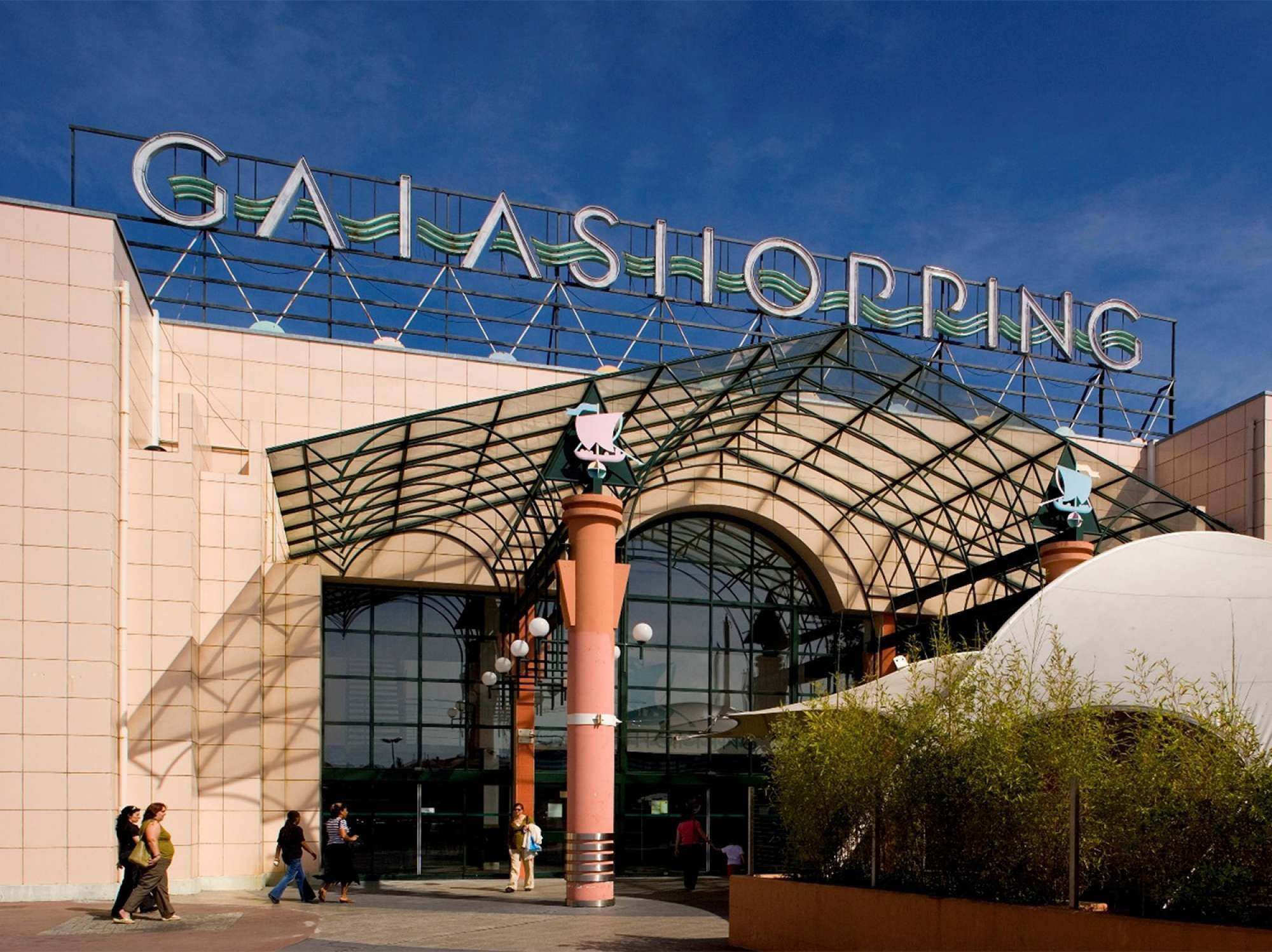 The exterior of a shopping mall with a prominent sign reading "GAIA SHOPPING".