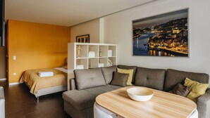 Et moderne hotelværelse med seng, sofa, lille bord og bogreol.