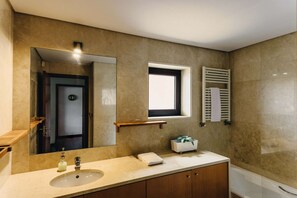 Een bad/douchecombinatie, een haardroger, een bidet, handdoeken