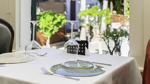 A dining table set for two with a view of a residential street through a window. - No16 Ada  (Adalar)