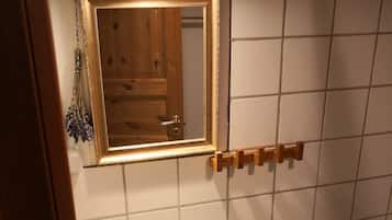 A bathroom with a white sink, a mirror with a gold frame, and a towel rack.