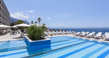 Una piscina al aire libre de temporada, sombrillas