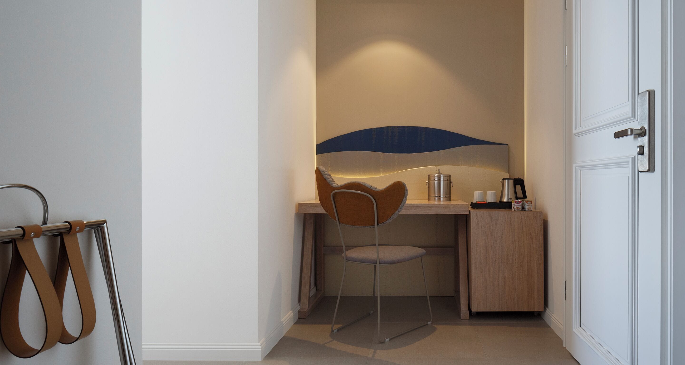 A compact room with a desk, chair, and a small cabinet.