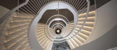 A spiral staircase with a central open area and a marble floor.