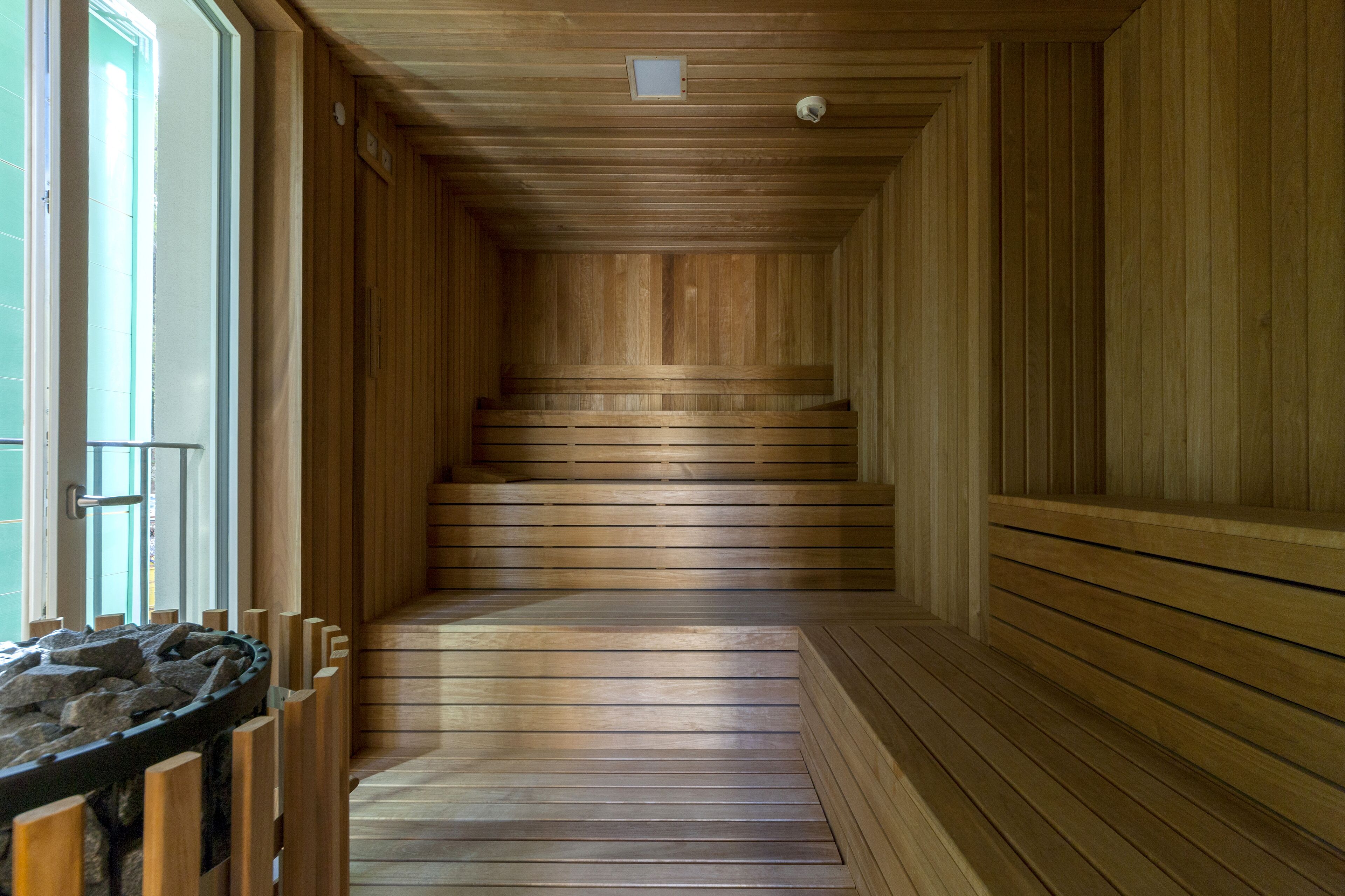 A wooden interior with a central staircase, wooden walls, and a stone basin.