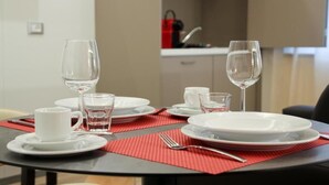Ein Esstisch mit weißen Tellern, Tassen und Gläsern, dazu eine rote Tischunterlage.