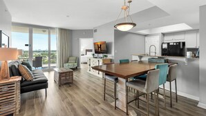 A modern kitchen with a dining area, large windows, and a view of the city. - Palms 2916 | Beach Nearby + Lagoon Pool🌴 (Destin)