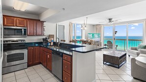 Una cocina moderna con una isla grande, electrodomésticos de acero inoxidable y armarios de madera.