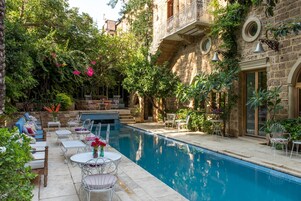 Una piscina al aire libre de temporada, sombrillas