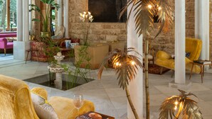 A spacious lobby with high ceilings, a large painting, and a central palm tree. - Arthaus Beirut (Beirut)